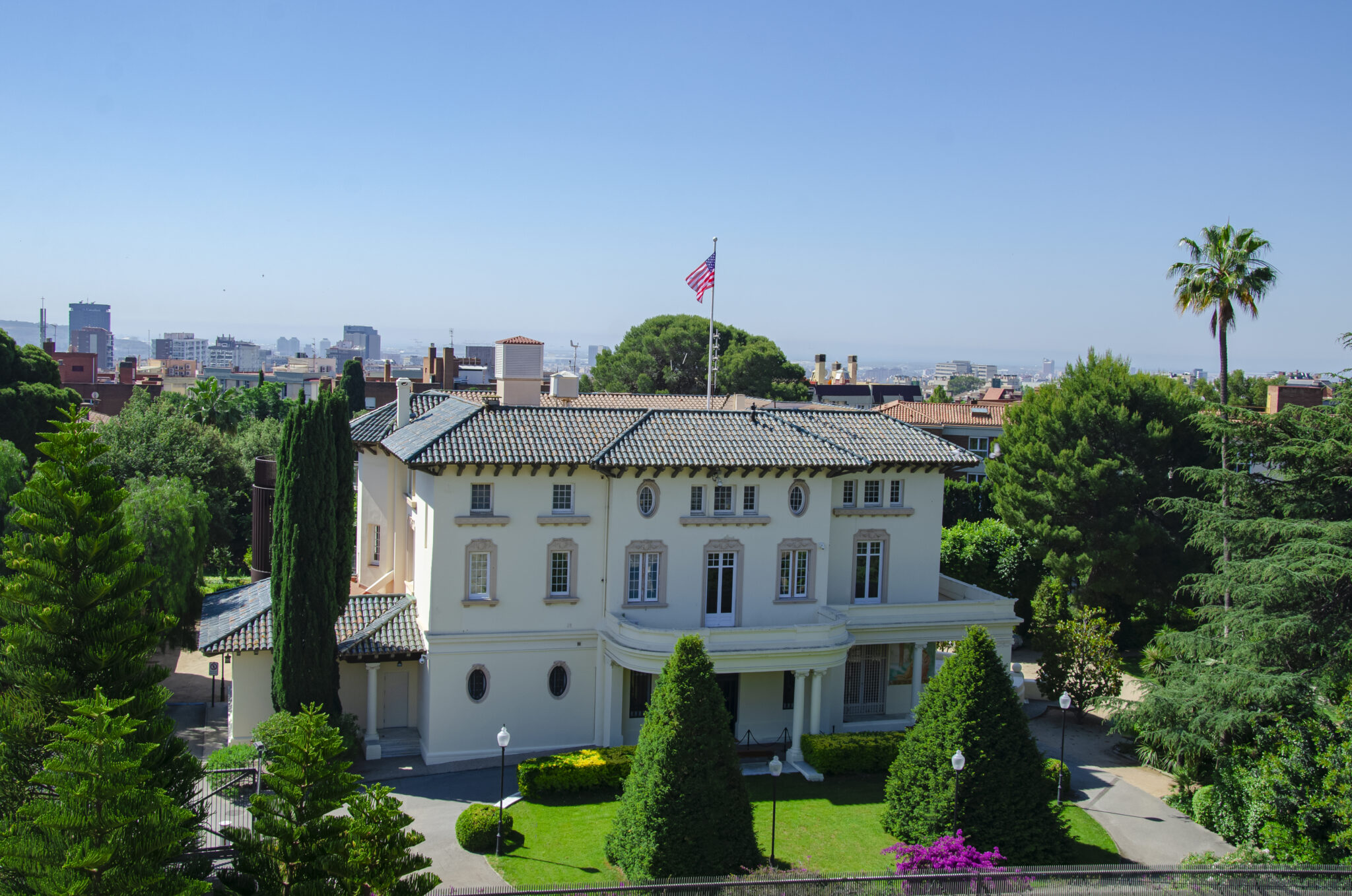 An aerial view of the U.S. Consulate Barcelona. This image captures the building’s color prior to restoration in 2024 – 2025. Barcelona first welcomed American diplomats in 1797 on orders from second U.S. President John Adams. Samuel Rubio